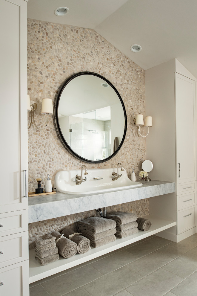 Idée de décoration pour une salle de bain tradition avec un placard à porte shaker, des portes de placard beiges, un carrelage multicolore, une plaque de galets, une grande vasque, un plan de toilette en marbre, un sol gris et un mur en pierre.