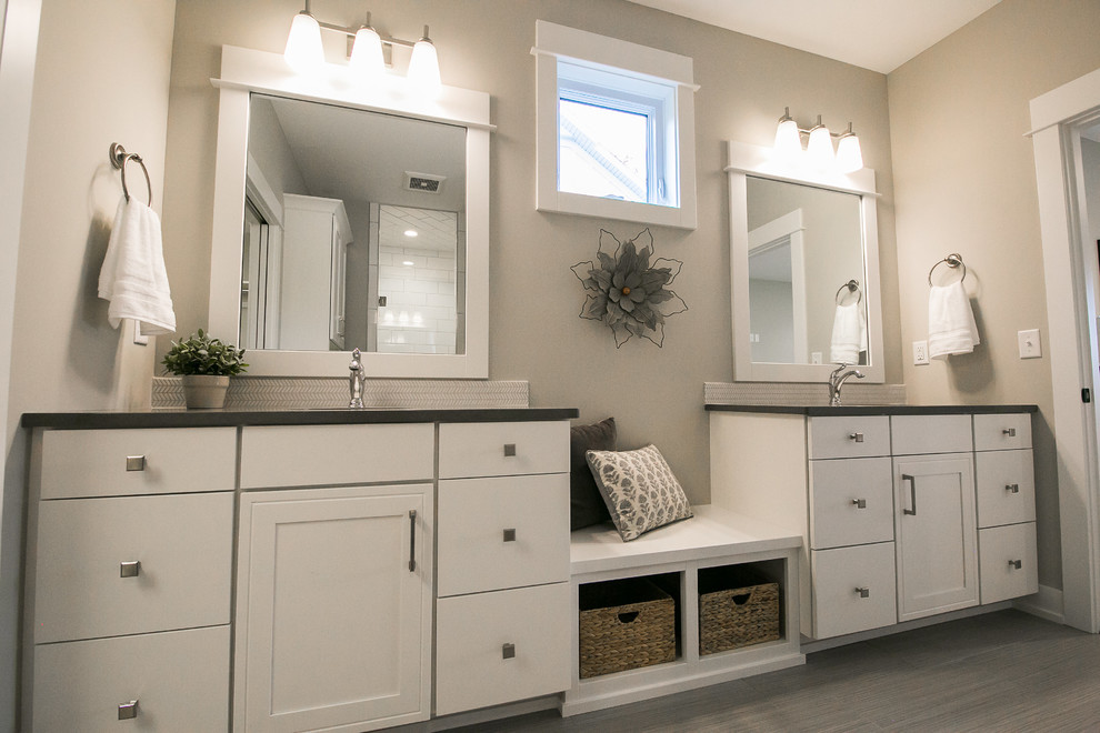 Alcove shower - mid-sized farmhouse master gray tile gray floor and porcelain tile alcove shower idea in Grand Rapids with flat-panel cabinets, white cabinets, a two-piece toilet, gray walls, an undermount sink, quartz countertops, a hinged shower door and gray countertops