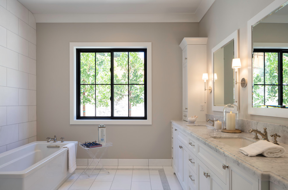 Bild på ett mellanstort lantligt grå grått en-suite badrum, med skåp i shakerstil, vita skåp, ett fristående badkar, grå kakel, keramikplattor, grå väggar, klinkergolv i keramik, ett undermonterad handfat, marmorbänkskiva och grått golv