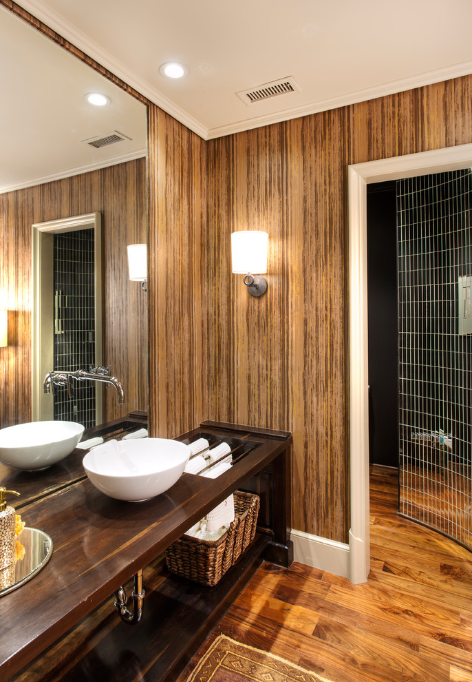Aménagement d'une salle de bain contemporaine en bois foncé avec une vasque, un placard sans porte et un plan de toilette en bois.