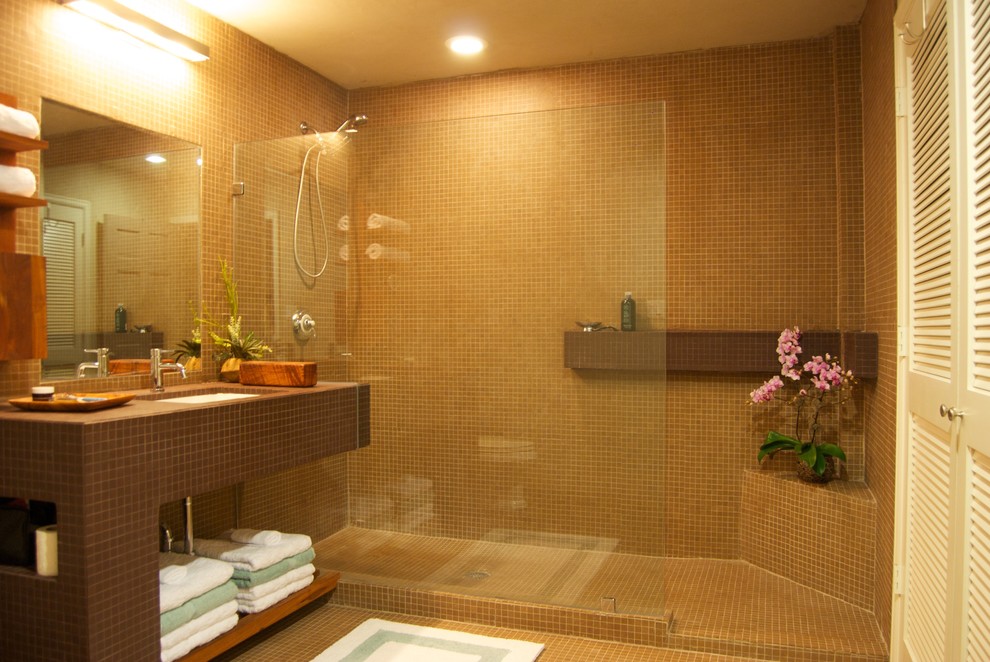 Exempel på ett litet modernt badrum med dusch, med en öppen dusch, brun kakel, klinkergolv i keramik, ett undermonterad handfat, kaklad bänkskiva, öppna hyllor, bruna skåp, en toalettstol med hel cisternkåpa, keramikplattor och bruna väggar