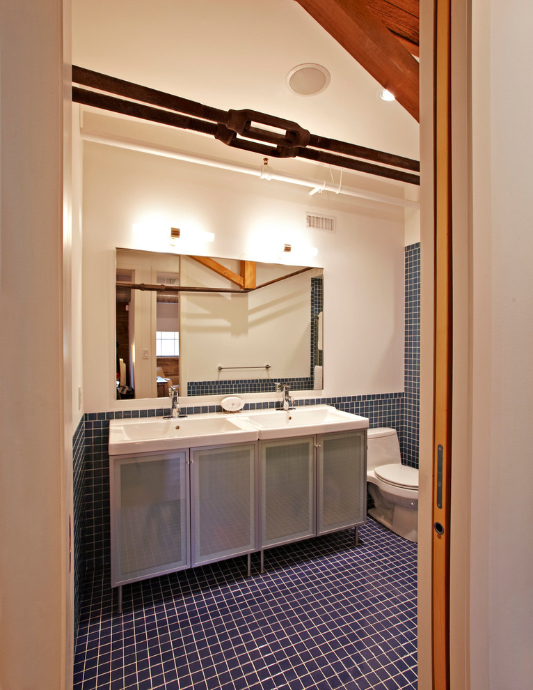 Immagine di una stanza da bagno per bambini minimalista con lavabo integrato, ante di vetro, WC monopezzo, piastrelle blu, piastrelle in ceramica, pareti bianche e pavimento con piastrelle in ceramica