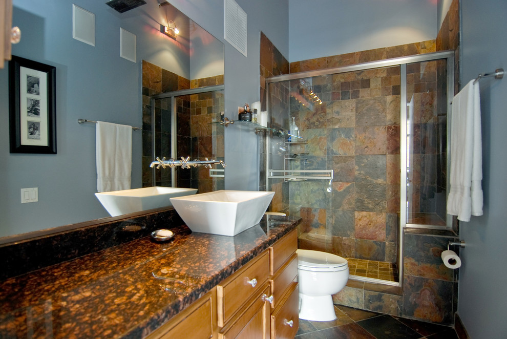 На фото: ванная комната среднего размера в современном стиле с фасадами островного типа, светлыми деревянными фасадами, душем в нише, раздельным унитазом, бежевой плиткой, черной плиткой, коричневой плиткой, серой плиткой, разноцветной плиткой, оранжевой плиткой, плиткой из сланца, серыми стенами, полом из сланца, душевой кабиной, настольной раковиной, столешницей из гранита, коричневым полом и душем с раздвижными дверями