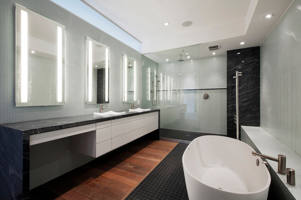 Diseño de cuarto de baño moderno de tamaño medio con lavabo encastrado, armarios con paneles lisos, puertas de armario blancas, encimera de mármol, ducha empotrada, baldosas y/o azulejos blancos, paredes blancas y suelo de madera en tonos medios