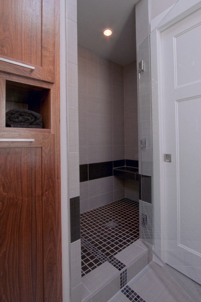 Inredning av ett modernt mellanstort en-suite badrum, med ett undermonterad handfat, skåp i shakerstil, skåp i mellenmörkt trä, bänkskiva i kvarts, en dusch i en alkov, en toalettstol med separat cisternkåpa, grå kakel, porslinskakel, grå väggar och klinkergolv i porslin