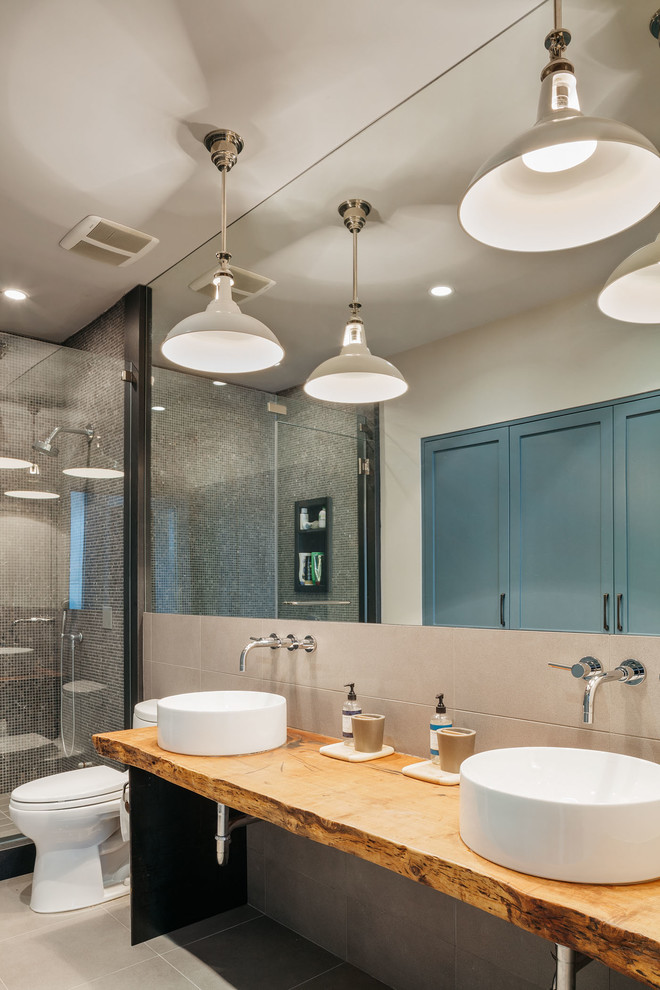 Modelo de cuarto de baño contemporáneo con lavabo sobreencimera, encimera de madera, ducha empotrada y baldosas y/o azulejos beige