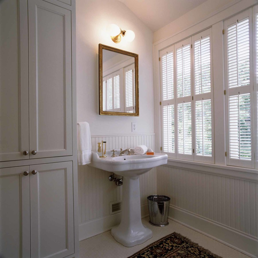 Idéer för ett klassiskt en-suite badrum, med ett piedestal handfat, luckor med infälld panel, skåp i slitet trä, en toalettstol med hel cisternkåpa, beige kakel, vita väggar och klinkergolv i keramik