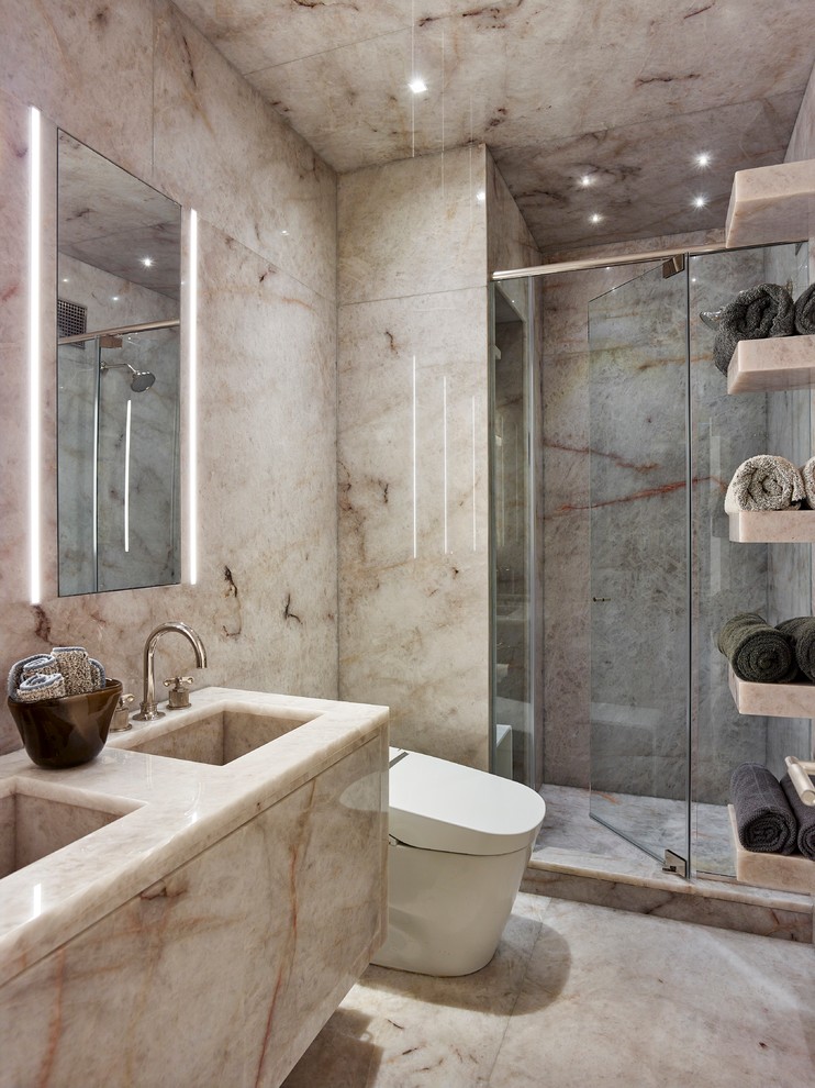 Inspiration för ett mellanstort funkis en-suite badrum, med en dusch i en alkov, en toalettstol med hel cisternkåpa, beige kakel, stenhäll, beige väggar, marmorgolv, ett integrerad handfat och marmorbänkskiva