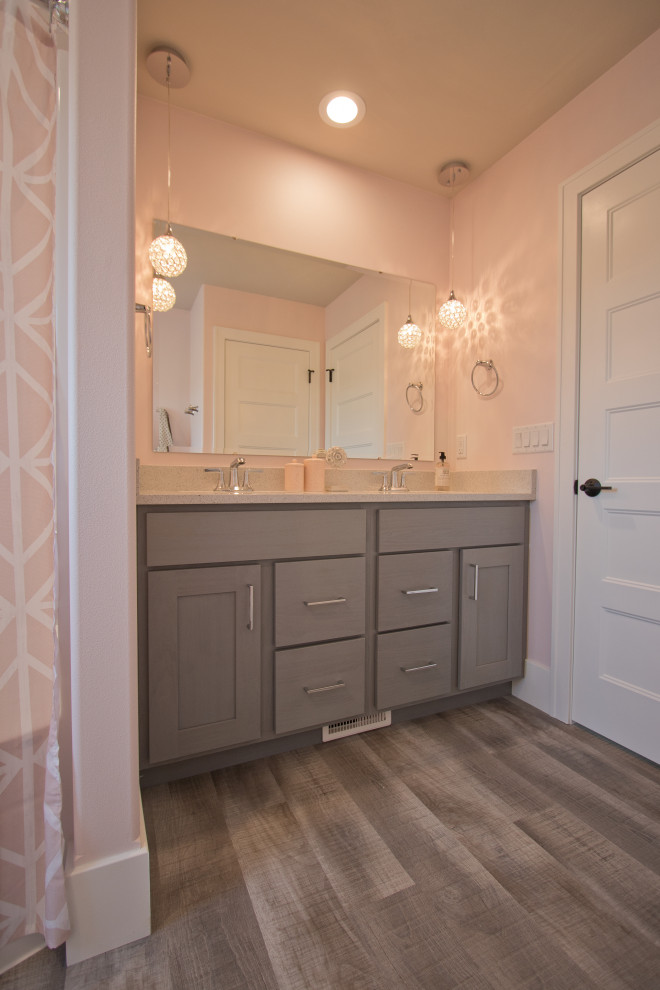 Photo of a bathroom in Other with grey cabinets, a built-in bath, a submerged sink, engineered stone worktops, white worktops, double sinks, a built in vanity unit, a two-piece toilet, pink walls, vinyl flooring and a shower curtain.