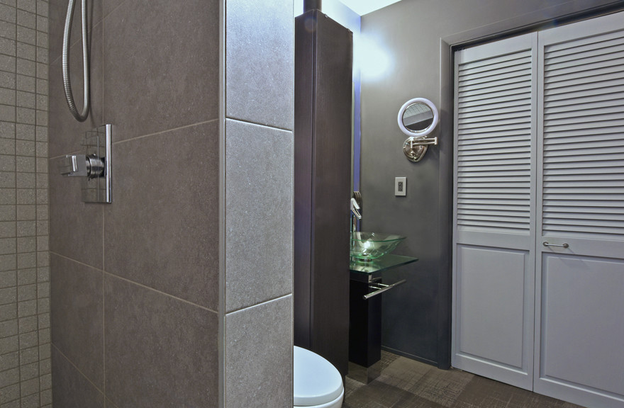 Inspiration pour une petite salle de bain principale minimaliste en bois foncé avec un placard à porte plane, une douche ouverte, WC à poser, un carrelage vert, un carrelage en pâte de verre, un mur gris, sol en béton ciré, un lavabo de ferme et un plan de toilette en verre.