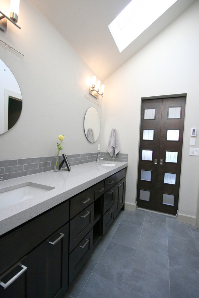 Photo of a medium sized modern ensuite bathroom in Portland with a submerged sink, shaker cabinets, dark wood cabinets, engineered stone worktops, an alcove shower, a two-piece toilet, grey tiles, porcelain tiles, grey walls and porcelain flooring.