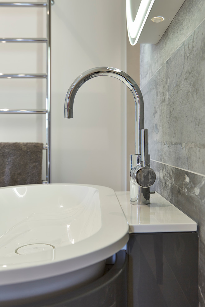 Large contemporary ensuite bathroom in Devon with a built-in bath, a walk-in shower, a wall mounted toilet, grey tiles, porcelain tiles, white walls, porcelain flooring and a wall-mounted sink.