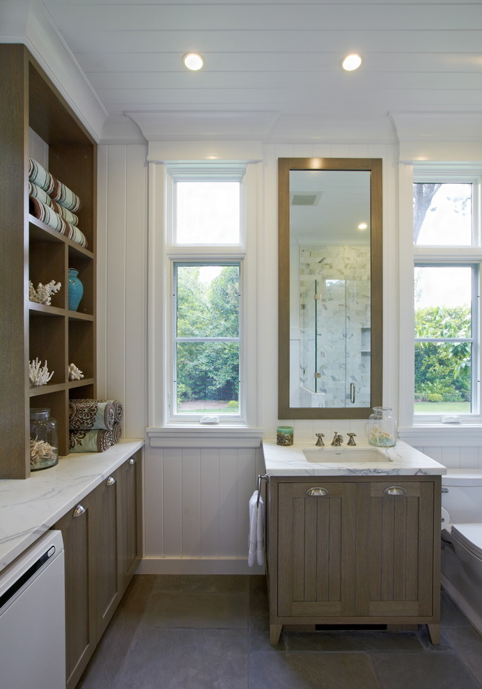 Diseño de cuarto de baño tradicional con lavabo bajoencimera, armarios estilo shaker, puertas de armario de madera oscura y tendedero