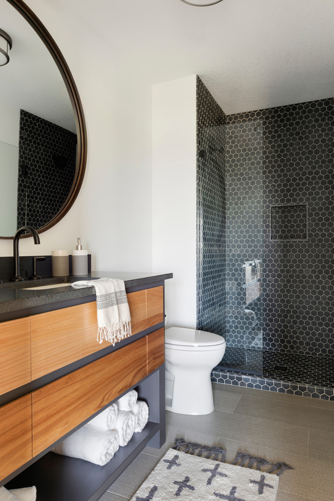 Idee per una stanza da bagno minimal con ante lisce, ante in legno scuro, piastrelle nere, piastrelle a mosaico, pareti bianche, lavabo sottopiano, pavimento grigio e top nero
