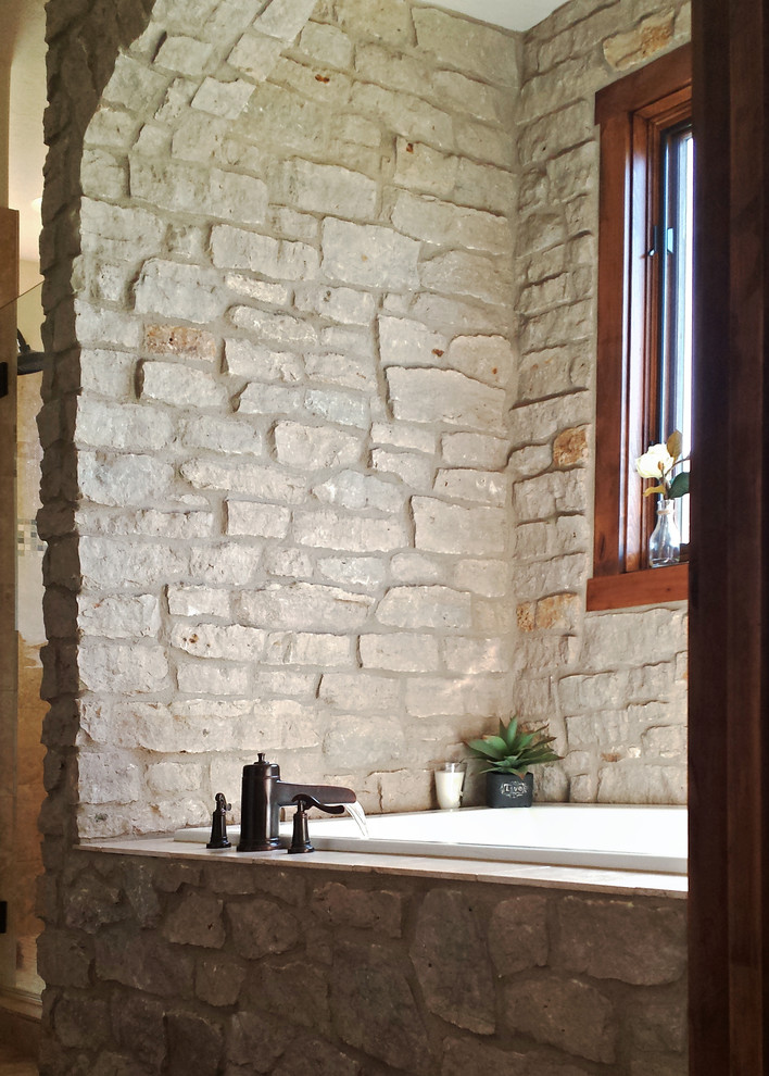 Imagen de cuarto de baño principal clásico de tamaño medio con lavabo sobreencimera, armarios con paneles empotrados, puertas de armario de madera en tonos medios, encimera de piedra caliza, bañera encastrada, ducha empotrada y paredes blancas