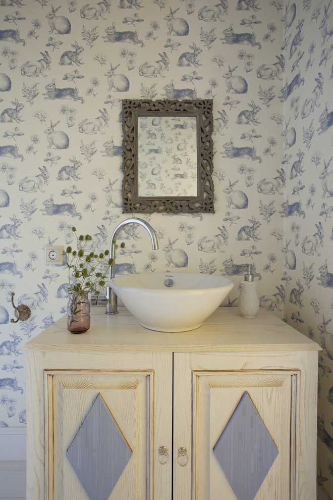 Inredning av ett shabby chic-inspirerat litet badrum, med skåp i ljust trä, flerfärgade väggar, ett fristående handfat och träbänkskiva
