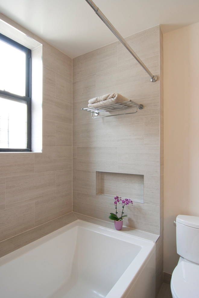 Идея дизайна: главная ванная комната среднего размера в современном стиле с плоскими фасадами, светлыми деревянными фасадами, ванной в нише, душем над ванной, раздельным унитазом, бежевой плиткой, керамогранитной плиткой, белыми стенами, полом из керамогранита, монолитной раковиной, столешницей из искусственного кварца, бежевым полом, шторкой для ванной и белой столешницей