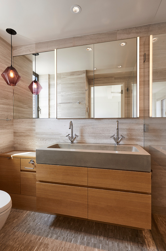 Foto de cuarto de baño actual con armarios con paneles lisos, puertas de armario de madera oscura, baldosas y/o azulejos beige, paredes beige, lavabo integrado y suelo beige