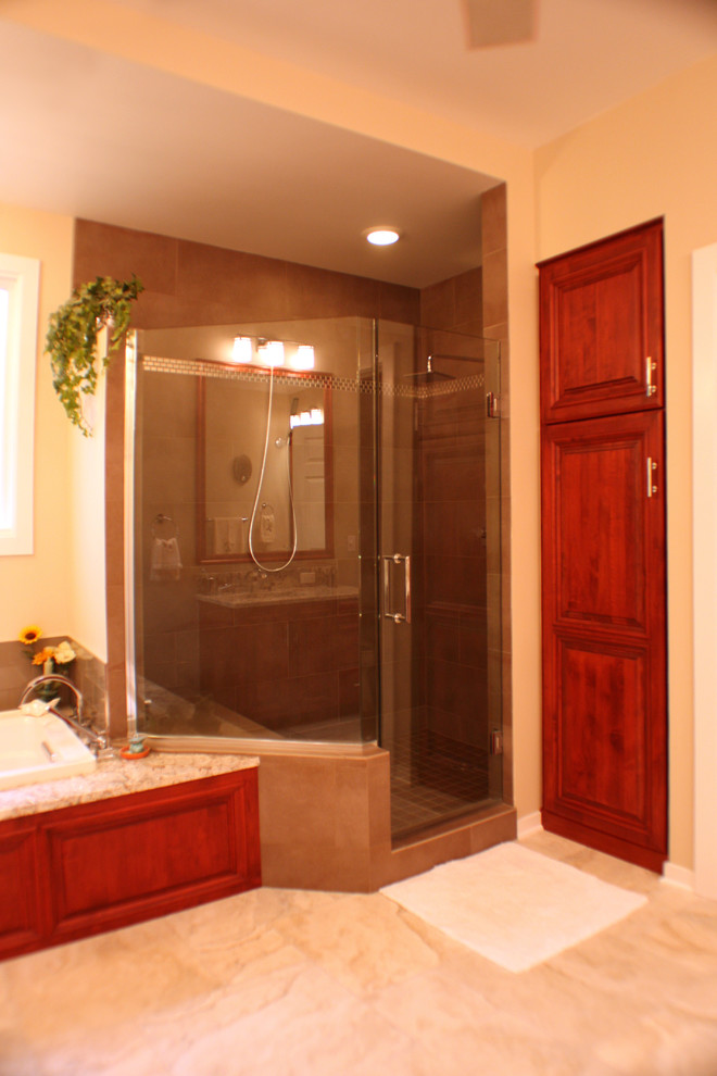 Example of a large classic master multicolored tile and porcelain tile porcelain tile bathroom design in Grand Rapids with raised-panel cabinets, medium tone wood cabinets, a two-piece toilet, beige walls, an undermount sink and granite countertops