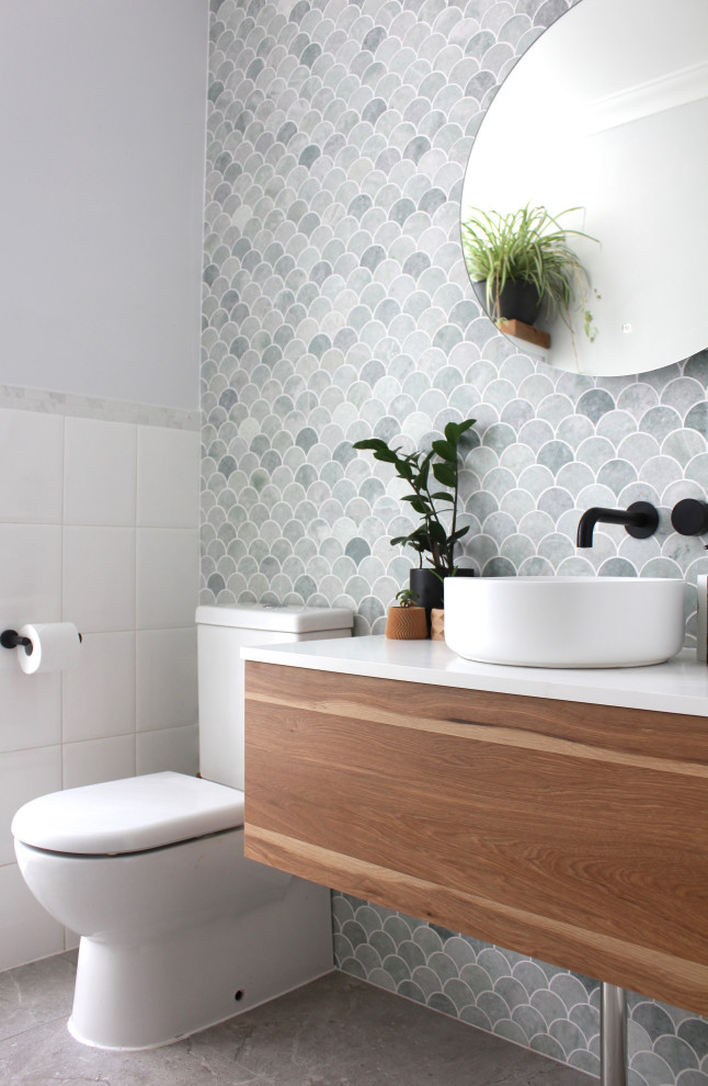 Exemple d'une petite salle de bain rétro en bois brun avec WC séparés, du carrelage en marbre, une vasque, un plan de toilette en quartz modifié, meuble simple vasque, meuble-lavabo suspendu, un placard à porte plane, un carrelage gris, un mur blanc, un sol gris et un plan de toilette blanc.