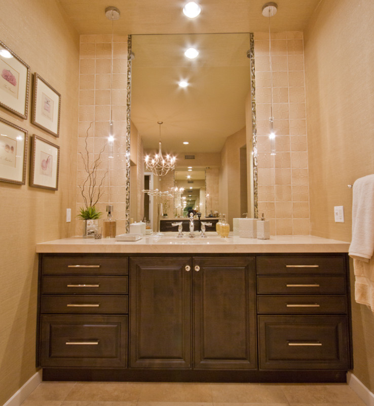 Cette image montre une salle de bain principale traditionnelle en bois brun avec un lavabo encastré, un placard avec porte à panneau surélevé, un plan de toilette en quartz modifié, WC à poser, un carrelage beige et un sol en travertin.