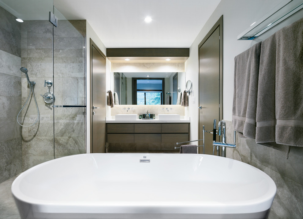 Inspiration for a medium sized contemporary shower room bathroom in Vancouver with flat-panel cabinets, dark wood cabinets, a freestanding bath, a double shower, a two-piece toilet, beige tiles, porcelain tiles, beige walls, medium hardwood flooring, a vessel sink, quartz worktops, grey floors and a hinged door.