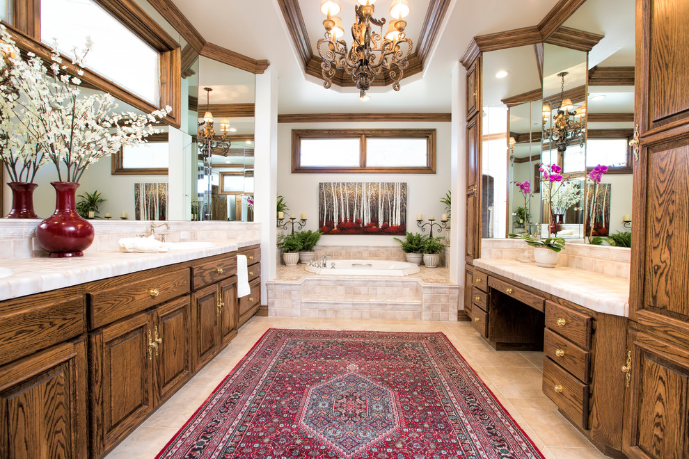 Immagine di una stanza da bagno padronale classica con lavabo da incasso, ante con bugna sagomata, ante in legno bruno e vasca da incasso