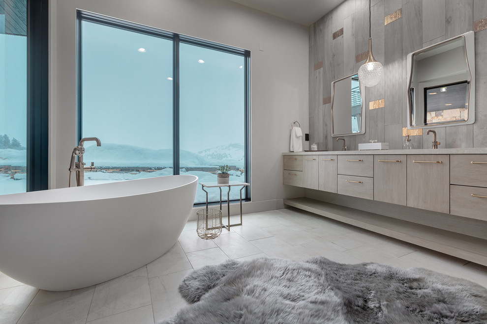 Immagine di una stanza da bagno contemporanea con ante lisce, ante grigie, vasca freestanding, pareti grigie, pavimento grigio e top grigio