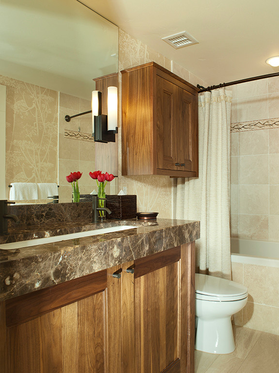 Esempio di una stanza da bagno contemporanea con ante in stile shaker, ante in legno bruno, top in marmo, vasca da incasso e pavimento in pietra calcarea