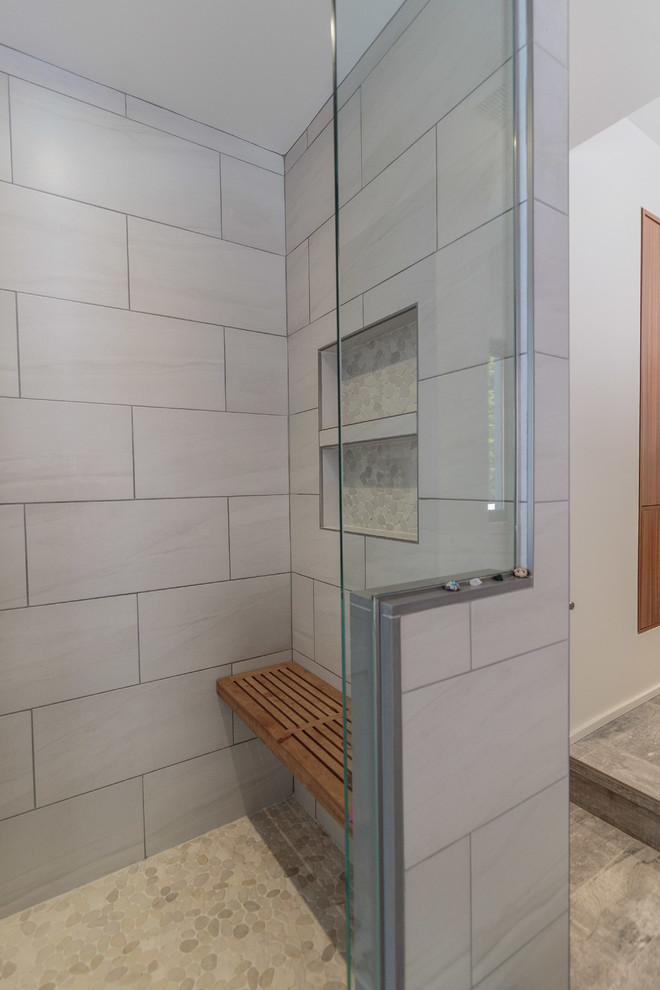 Large minimalist master gray tile and ceramic tile porcelain tile and gray floor bathroom photo in Montreal with flat-panel cabinets, medium tone wood cabinets, a one-piece toilet, white walls, an undermount sink, quartz countertops and a hinged shower door