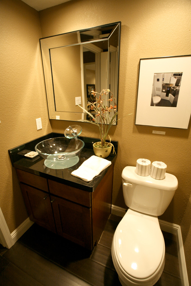 Cette image montre une petite salle de bain traditionnelle en bois foncé avec un placard à porte shaker, WC séparés, un mur beige, parquet foncé et une vasque.