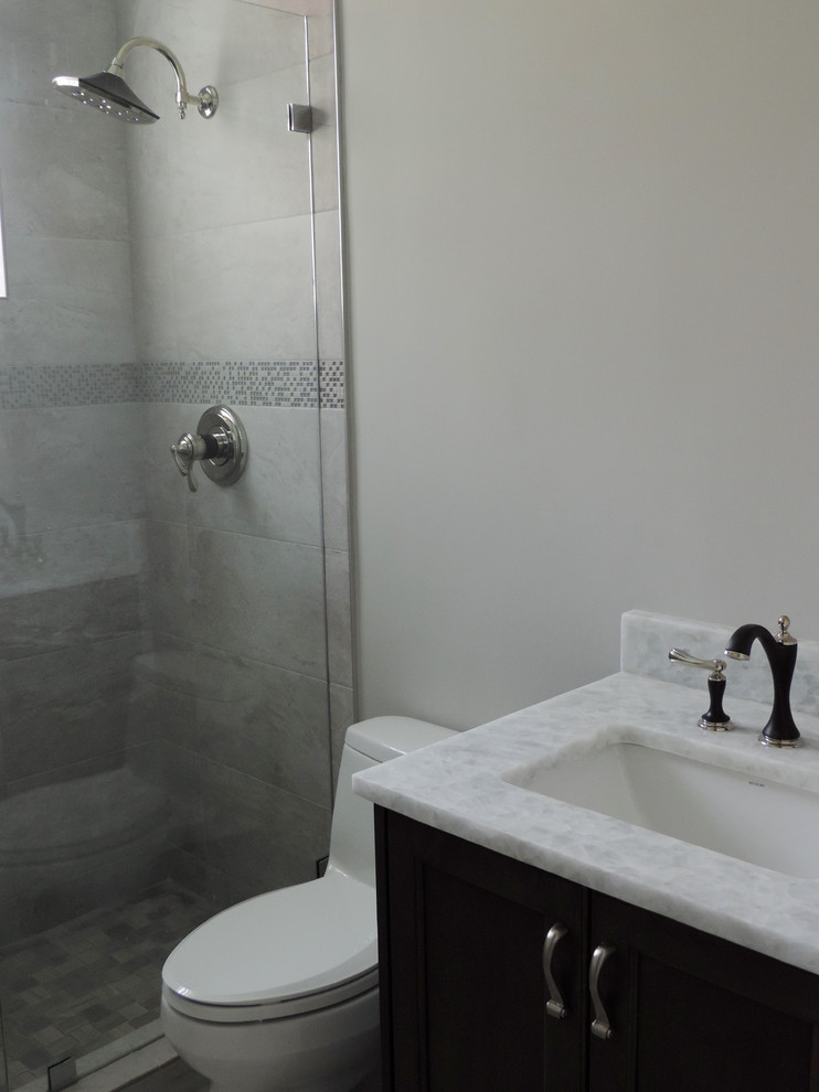 Foto de cuarto de baño contemporáneo pequeño con armarios con paneles lisos, puertas de armario de madera en tonos medios, sanitario de una pieza, aseo y ducha, lavabo bajoencimera y encimera de mármol