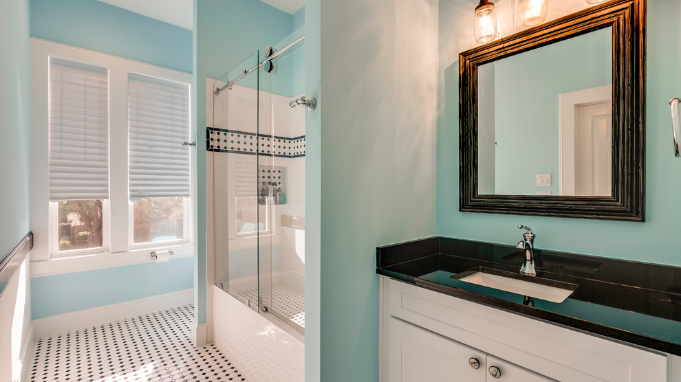 Стильный дизайн: ванная комната в классическом стиле с фасадами в стиле шейкер, белыми фасадами, душем над ванной, черной плиткой, черно-белой плиткой, белой плиткой, керамической плиткой, синими стенами, полом из мозаичной плитки, душевой кабиной, врезной раковиной, столешницей из искусственного кварца, белым полом, душем с раздвижными дверями и черной столешницей - последний тренд