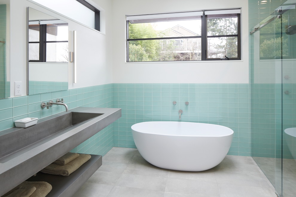 Пример оригинального дизайна: ванная комната в современном стиле с отдельно стоящей ванной, душем в нише, синей плиткой, стеклянной плиткой, белыми стенами, раковиной с несколькими смесителями, серым полом, душем с раздвижными дверями и серой столешницей