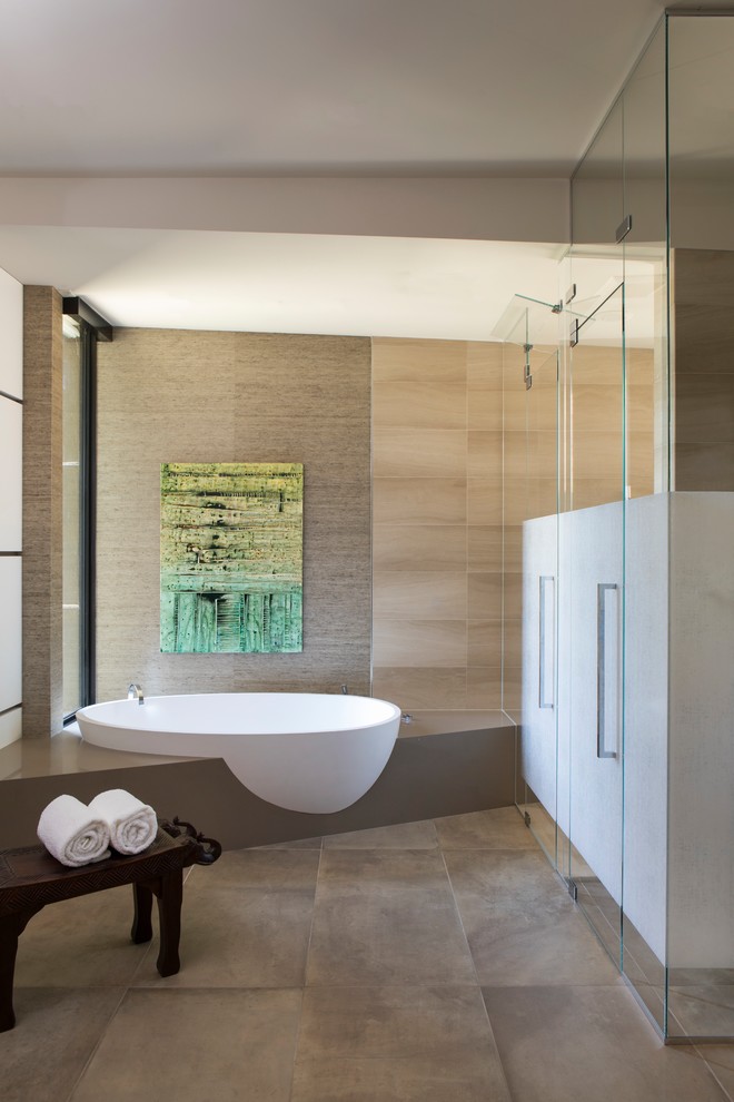 Cette photo montre une salle de bain principale tendance avec une baignoire posée, un carrelage gris, un sol gris et une cabine de douche à porte battante.