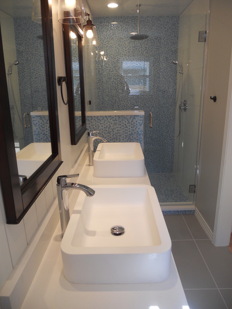 Foto på ett litet vintage en-suite badrum, med luckor med infälld panel, vita skåp, en dusch/badkar-kombination, en toalettstol med hel cisternkåpa, grå kakel, glaskakel, grå väggar, klinkergolv i porslin, ett fristående handfat och bänkskiva i kvartsit
