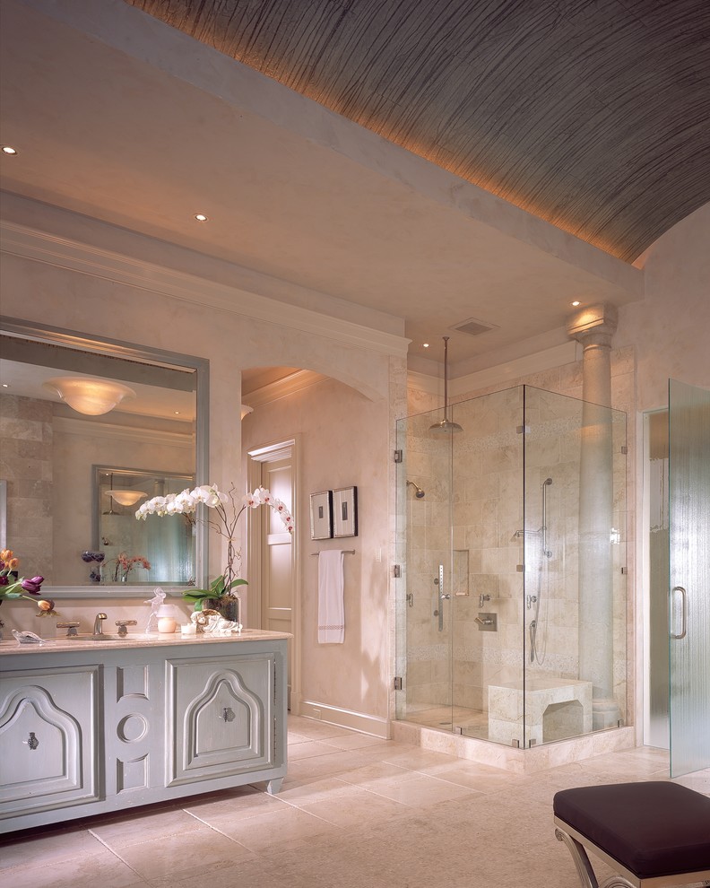 На фото: ванная комната в современном стиле с синими фасадами и плиткой из известняка с