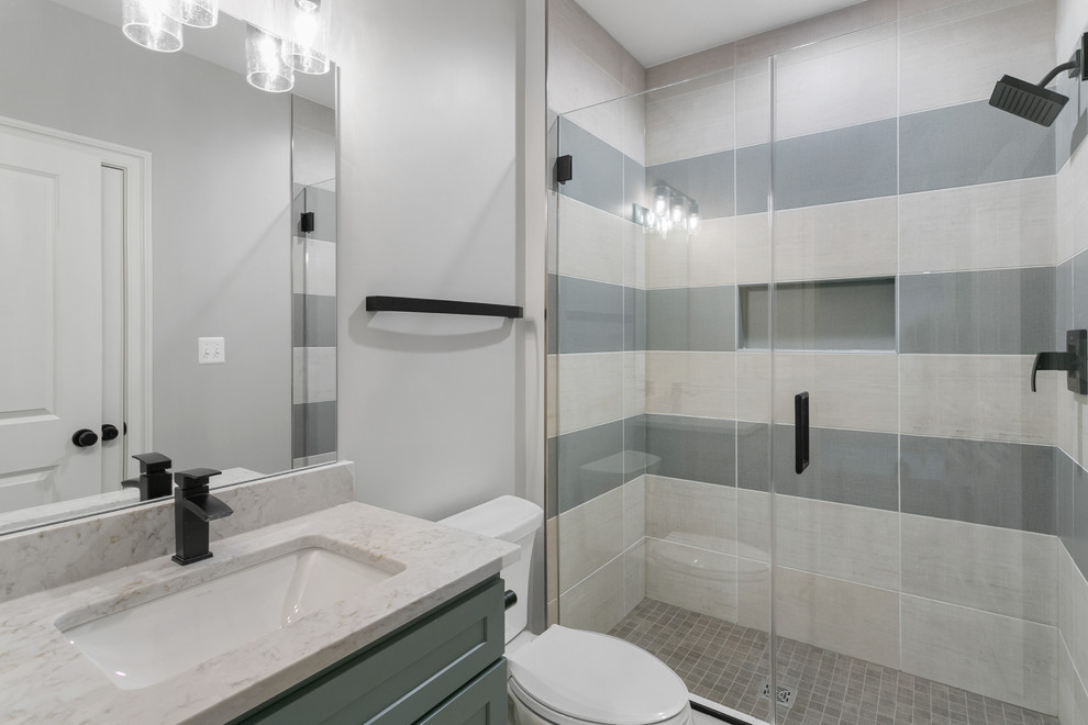 This is an example of a medium sized contemporary shower room bathroom in Other with shaker cabinets, grey cabinets, an alcove shower, a one-piece toilet, multi-coloured tiles, white walls, a submerged sink, a hinged door and white worktops.