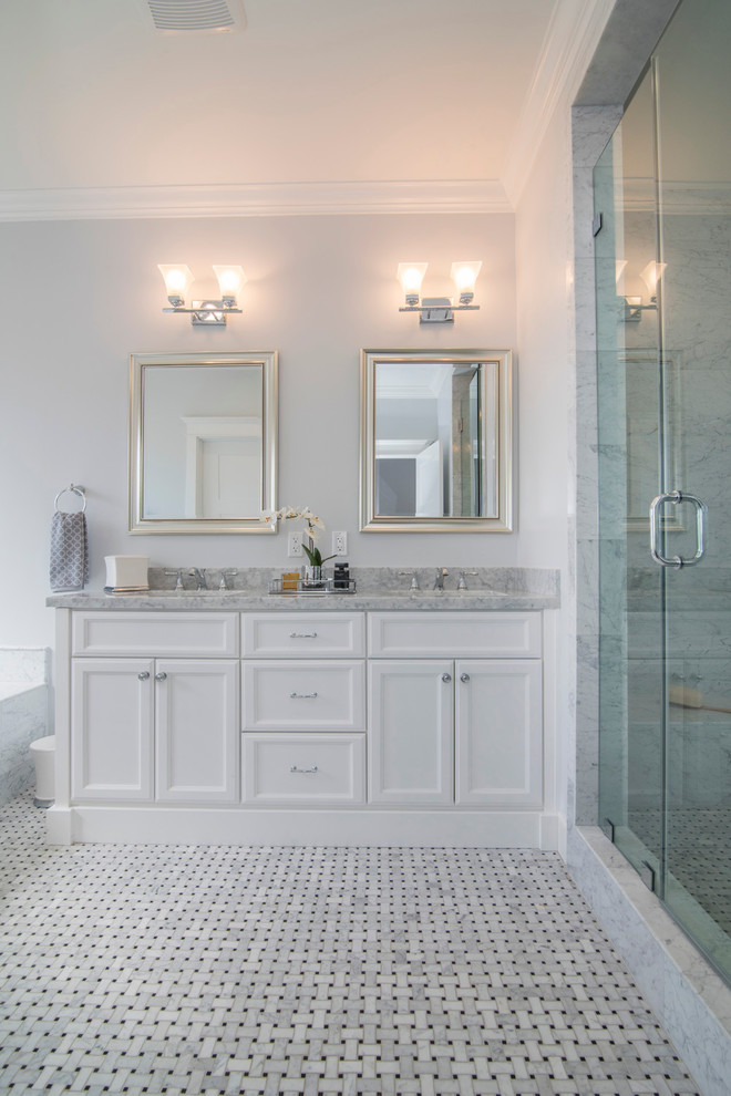 Klassisk inredning av ett stort en-suite badrum, med ett undermonterad handfat, vita skåp, marmorbänkskiva, en dusch i en alkov, vit kakel, grå kakel, luckor med infälld panel, ett platsbyggt badkar, marmorkakel, grå väggar och marmorgolv
