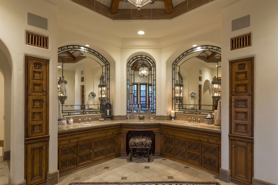 Expansive mediterranean ensuite bathroom in Phoenix with freestanding cabinets, medium wood cabinets, beige tiles, stone tiles, beige walls, limestone flooring, a submerged sink and limestone worktops.