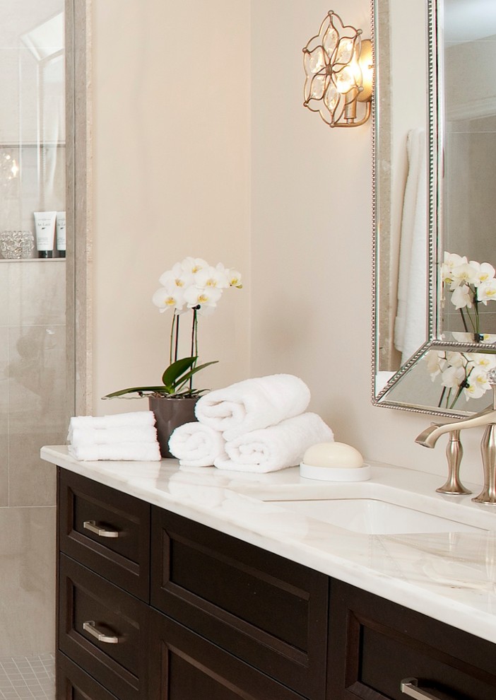 Mid-sized transitional master beige tile and porcelain tile porcelain tile bathroom photo in Toronto with an undermount sink, furniture-like cabinets, dark wood cabinets, marble countertops, a two-piece toilet and beige walls