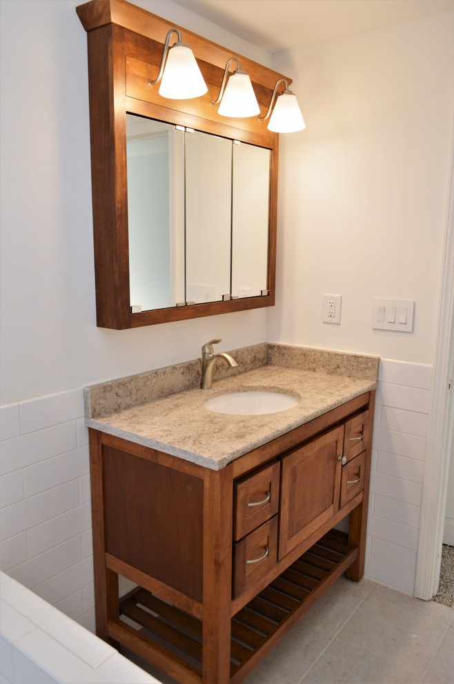 Inspiration pour une salle de bain principale style shabby chic en bois brun de taille moyenne avec un placard à porte shaker, un carrelage blanc, un carrelage métro, un mur blanc, un lavabo encastré, un plan de toilette en quartz et un plan de toilette beige.