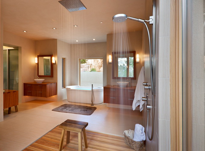 This is an example of a medium sized ensuite bathroom in Albuquerque with flat-panel cabinets, light wood cabinets, a freestanding bath, a walk-in shower, a one-piece toilet, porcelain tiles, beige walls, light hardwood flooring, a vessel sink and wooden worktops.