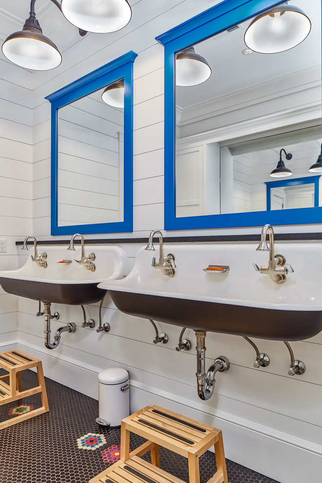 Diseño de cuarto de baño infantil marinero con paredes blancas, lavabo de seno grande y suelo multicolor