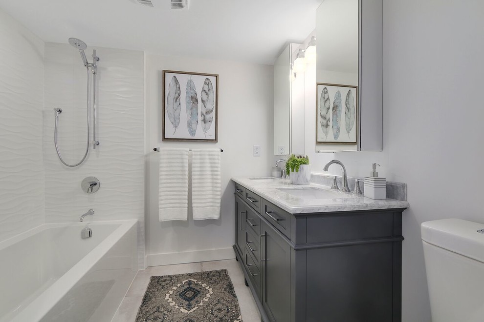 Inspiration for a small classic bathroom in Vancouver with recessed-panel cabinets, grey cabinets, a shower/bath combination, a one-piece toilet, ceramic tiles, porcelain flooring, an alcove bath, white tiles, white walls, a submerged sink, marble worktops and grey floors.