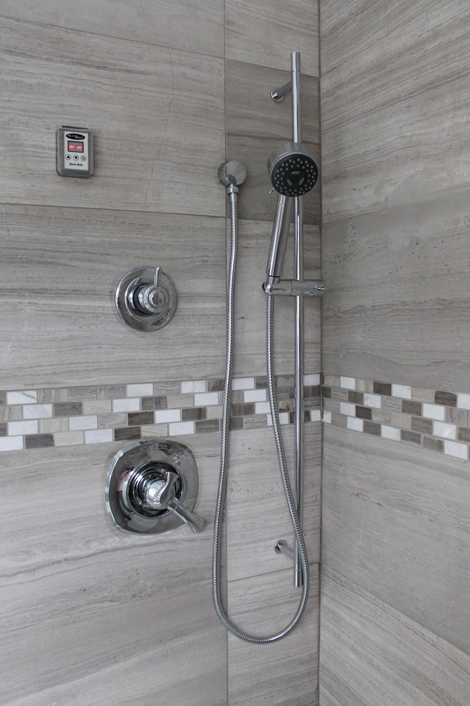 Mid-sized elegant 3/4 white tile and stone tile travertine floor alcove shower photo in Vancouver with flat-panel cabinets, gray cabinets, a one-piece toilet, white walls, an undermount sink and quartz countertops