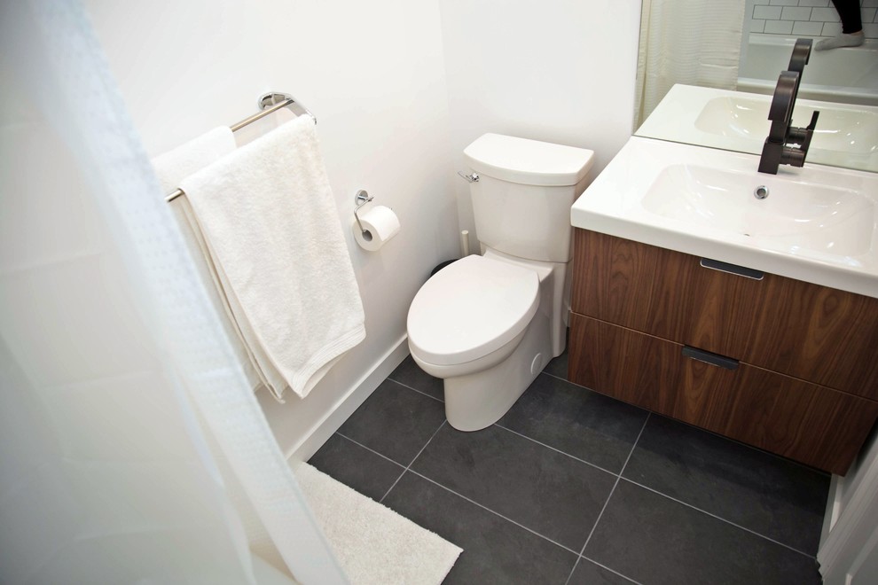 Exempel på ett litet modernt badrum, med släta luckor, skåp i mellenmörkt trä, en dusch/badkar-kombination, en toalettstol med separat cisternkåpa, vita väggar, klinkergolv i porslin, ett väggmonterat handfat, svart golv och dusch med duschdraperi