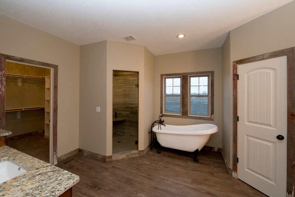 Exempel på ett stort klassiskt en-suite badrum, med luckor med upphöjd panel, skåp i mörkt trä, ett badkar med tassar, beige väggar, mellanmörkt trägolv, ett undermonterad handfat och granitbänkskiva