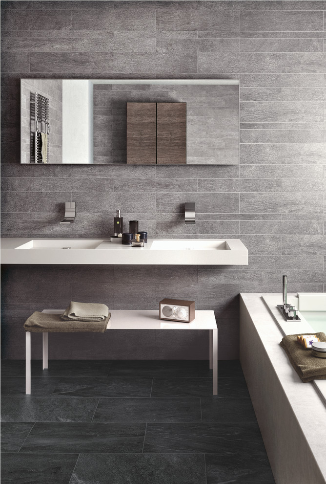 Immagine di una stanza da bagno padronale minimalista di medie dimensioni con lavabo sospeso, vasca ad alcova, doccia alcova, piastrelle grigie, lastra di pietra, pareti grigie e pavimento in ardesia