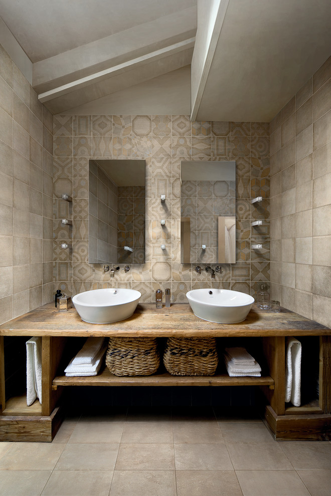 This is an example of a large mediterranean ensuite bathroom in New York with medium wood cabinets, wooden worktops, multi-coloured tiles, ceramic tiles, multi-coloured walls, ceramic flooring, open cabinets, a vessel sink, beige floors and brown worktops.